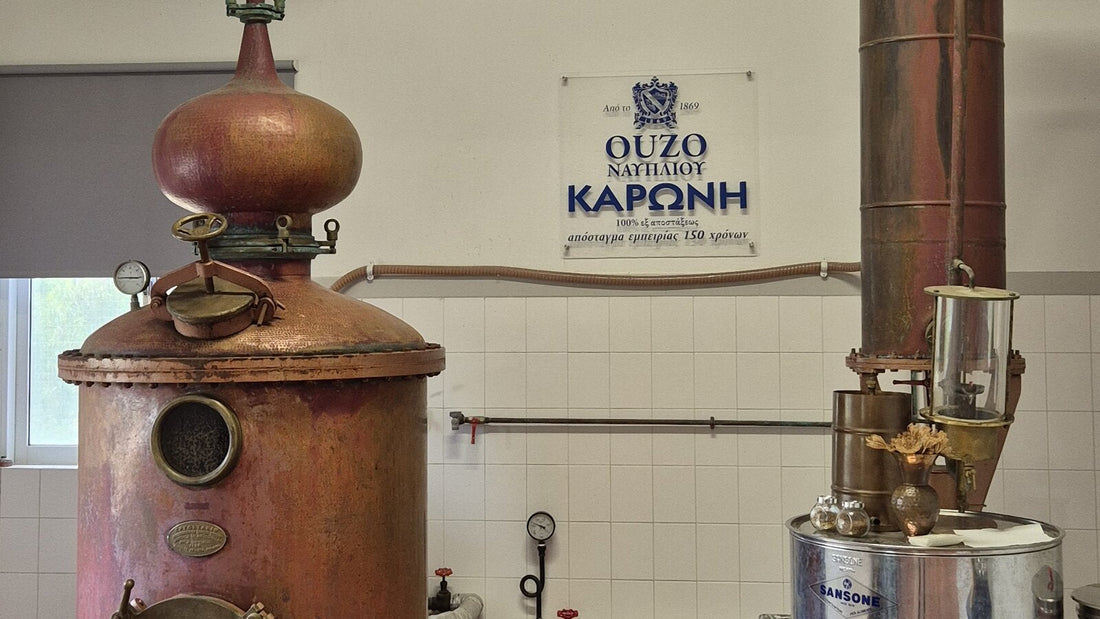 Kupferne Brennblase der Destillerie Karonis in Nafplio, dahinter das Schild „seit 1869"