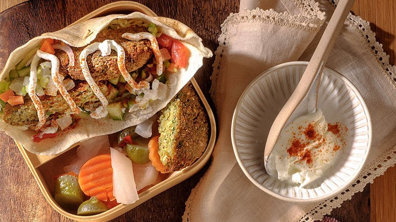 Kichererbsen-Burger im Fladenbrot mit frischem Gemüsesalat und Dip.